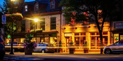 Exterior of heritage buildings in downtown Perth at night with cars driving in front of them