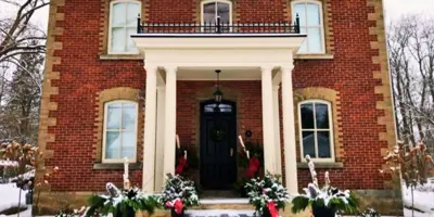 Front of brick heritage home during winter with snow on the ground