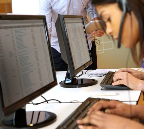 Lady with headset typing at computer