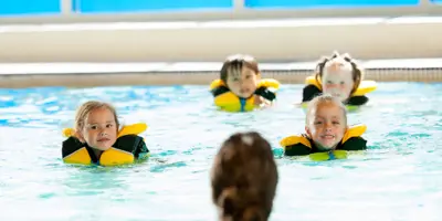 Children in the pool doing a swim lesson