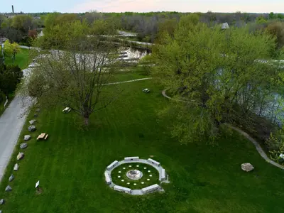 Aerial view of grassy area in park with a river running along the right