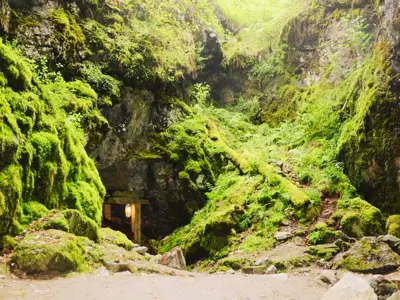 Entrance to mine, with green moss covering all of the rocks surrounding it