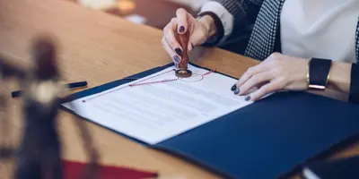 Woman at a deal stamping a document with a seal