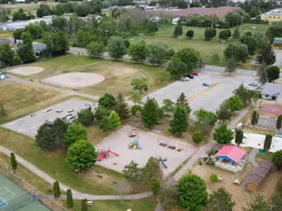 Aerial view of outdoor recreation complex, includes playground, tennis courts, baseball diamond, and parking lot